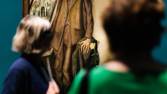 Photo: Visitors in front of a painting.