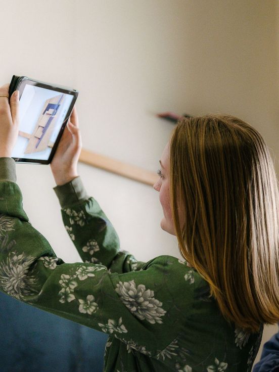 Photo: Two young visitors hold a tablet. It shows a photograph of a work of art.